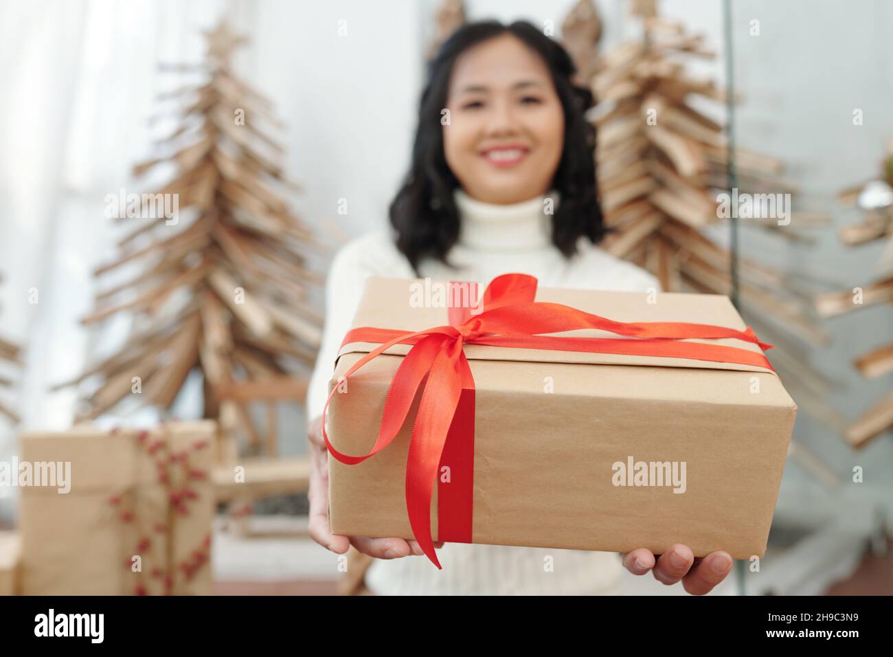 Happy woman giving Christmas present, focus on box Stock Photo - Alamy