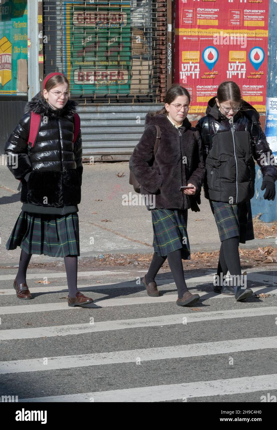 3 orthodox Jewish students dressed similarly, return from school on a Friday afternoon to prepare for the Sabbath. On Lee Avenue in Brooklyn, New York Stock Photo