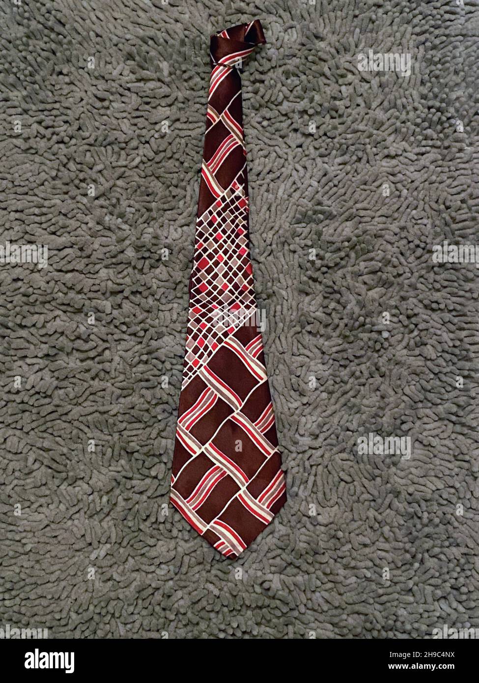 A brown and red Arrow brand Art Deco necktie with a beautiful period design. Likely from the 1940s or possibly the 1930's. Stock Photo
