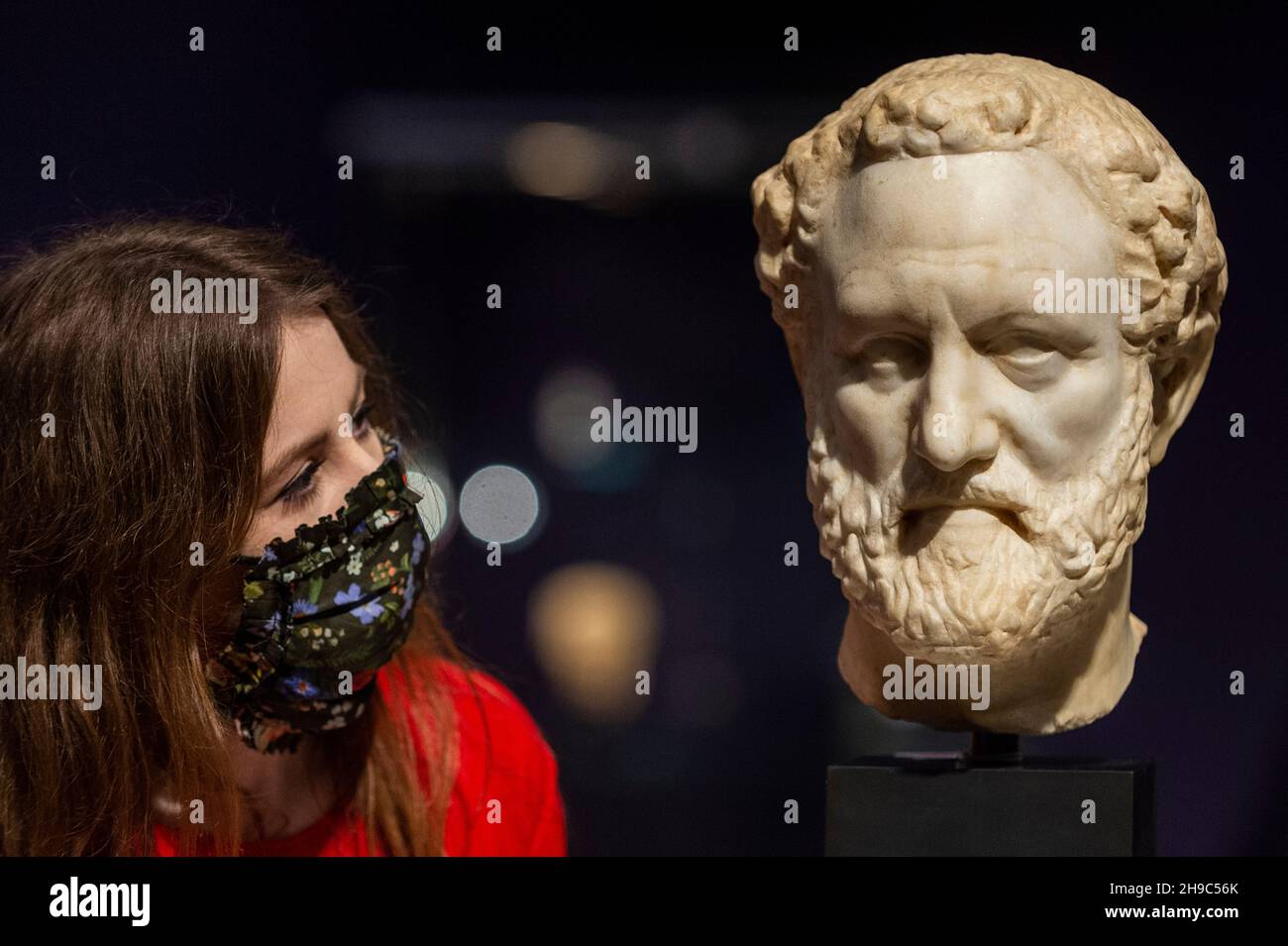 London, UK.  6 December 2021. A staff member views “A Roman marble portrait head, probably Thucydides”, Circa 150-175 A.D., (Est. £80,000 - 120,000) at a preview of the Bonhams Antiquities Sale.  The auction takes place on 7 December at Bonhams’ New Bond Street galleries.  Credit: Stephen Chung / Alamy Live News Stock Photo
