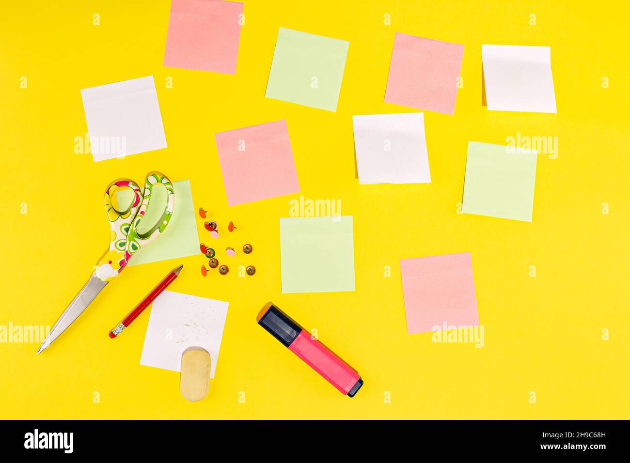 Studio photo with yellow background with stationery as post-its, pencil, scissors, eraser and marker Stock Photo