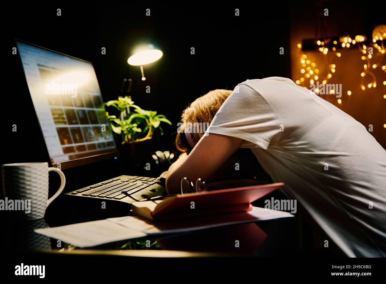 Woman sleeping on table at workplace. Overtime work concept. Working at night Stock Photo