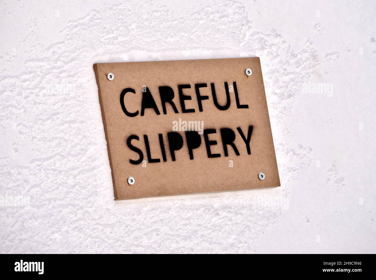 Careful slipper sign pinned to a snow wall Stock Photo