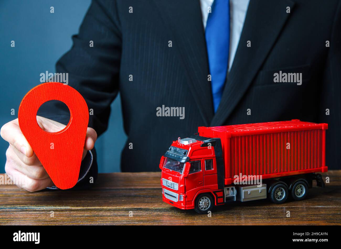 Truck and businessman with red location pin. Transport service infrastructure, business service. Logistics. Transportation company. Package tracking. Stock Photo