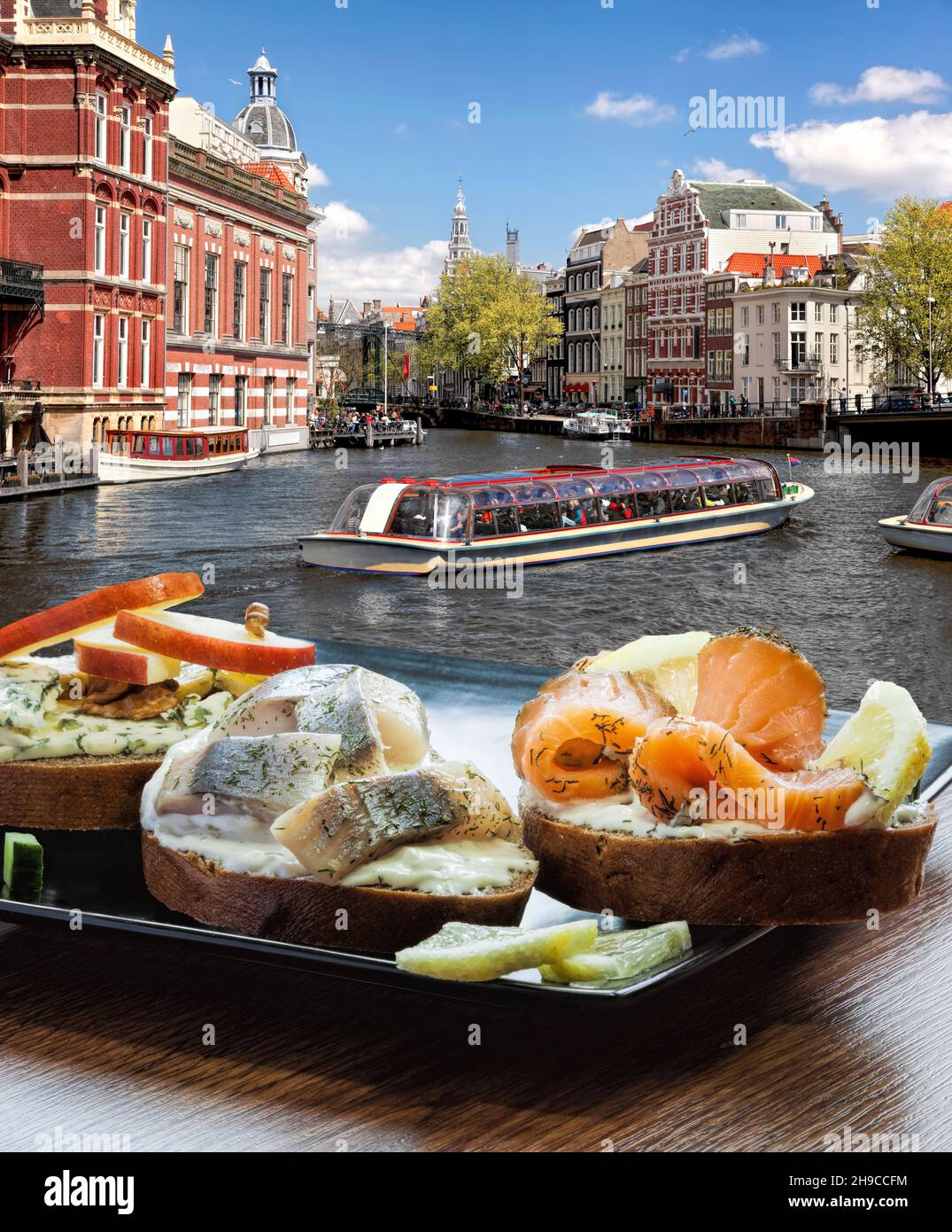 Amsterdam city with fishplate (salomon and codfish sandwiches) against  tourboat on canal in Netherlands Stock Photo - Alamy