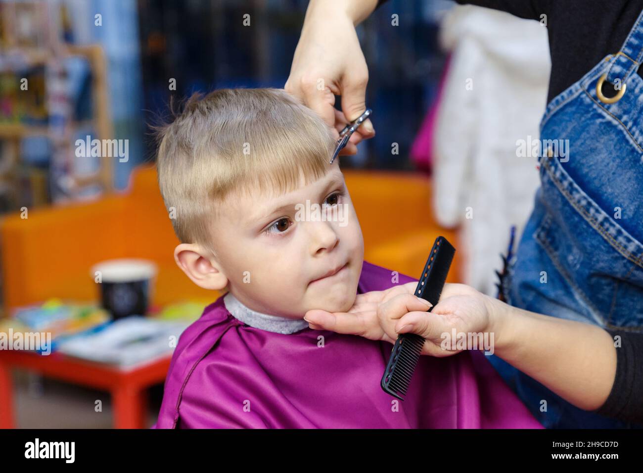 Haircut for a little boy in a special children's hairdressing salon