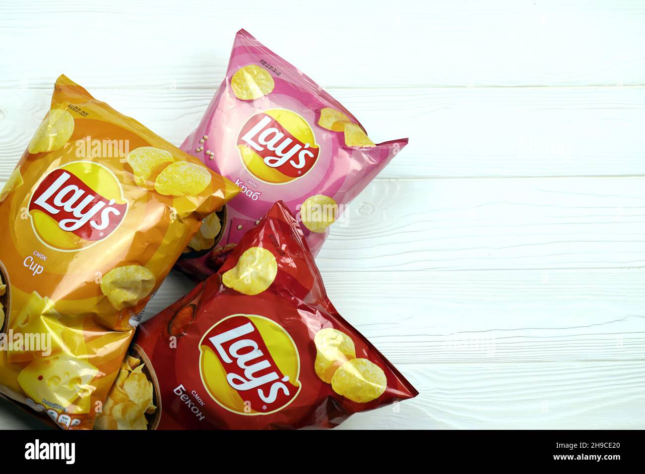 KHARKOV, UKRAINE JANUARY 3, 2021 Various flavoured of lay's potato chips on wooden background