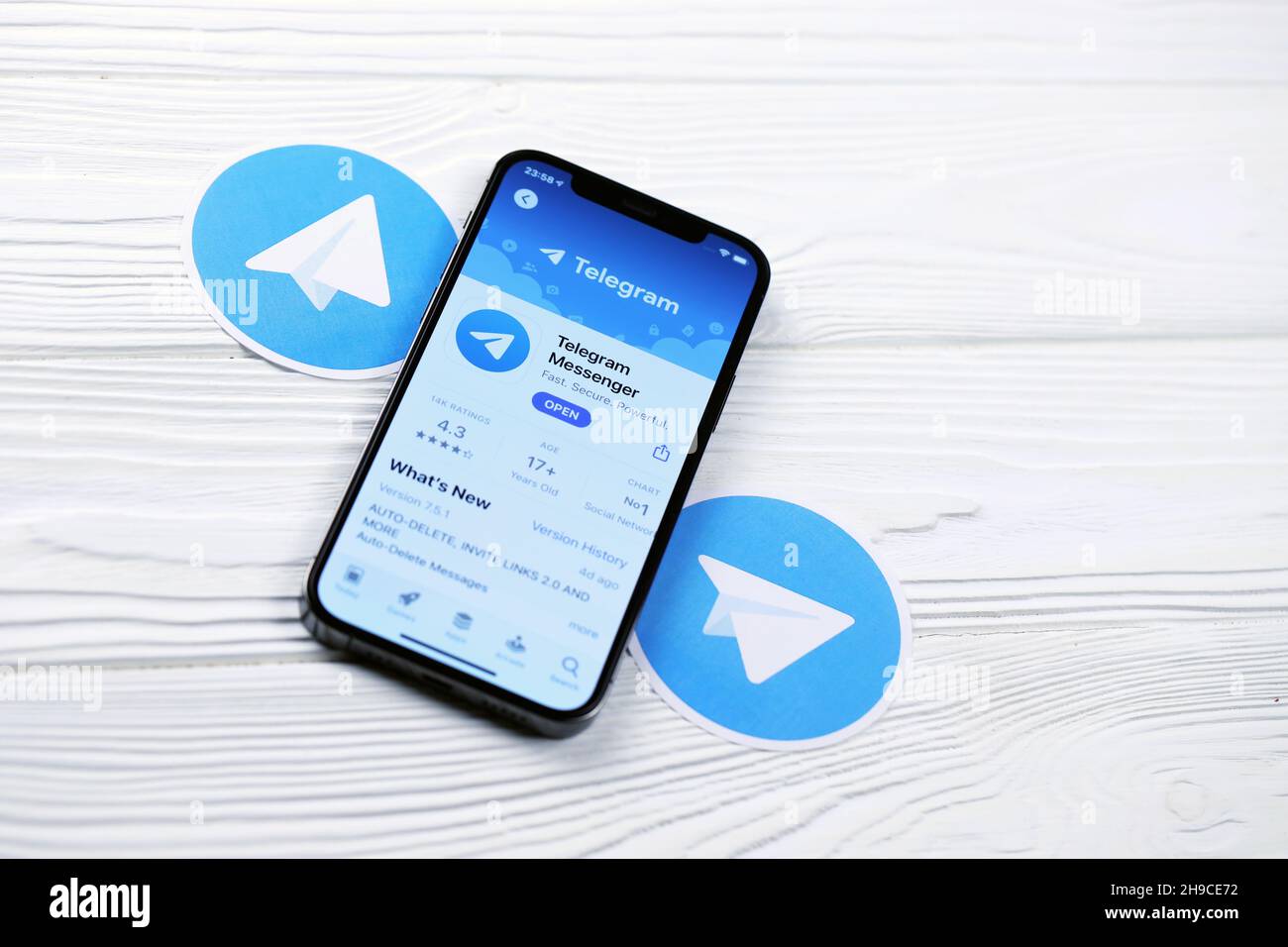 KHARKOV, UKRAINE - MARCH 5, 2021: Telegram Messenger icon and application from App store on iPhone 12 pro display screen on white wooden table Stock Photo