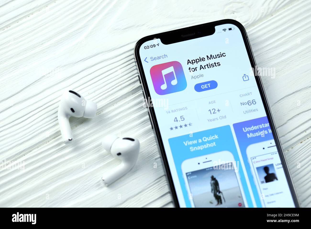 KHARKOV, UKRAINE - MARCH 5, 2021: Apple music for artists icon and application from App store on iPhone 12 pro display screen with airpods pro on whit Stock Photo