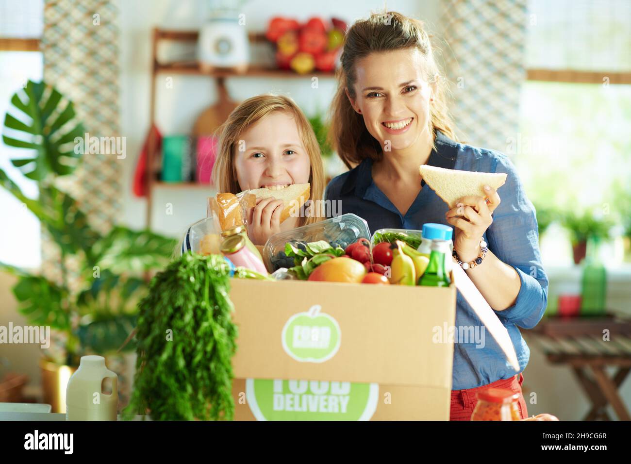 Food delivery. happy young mother and daughter with food box and