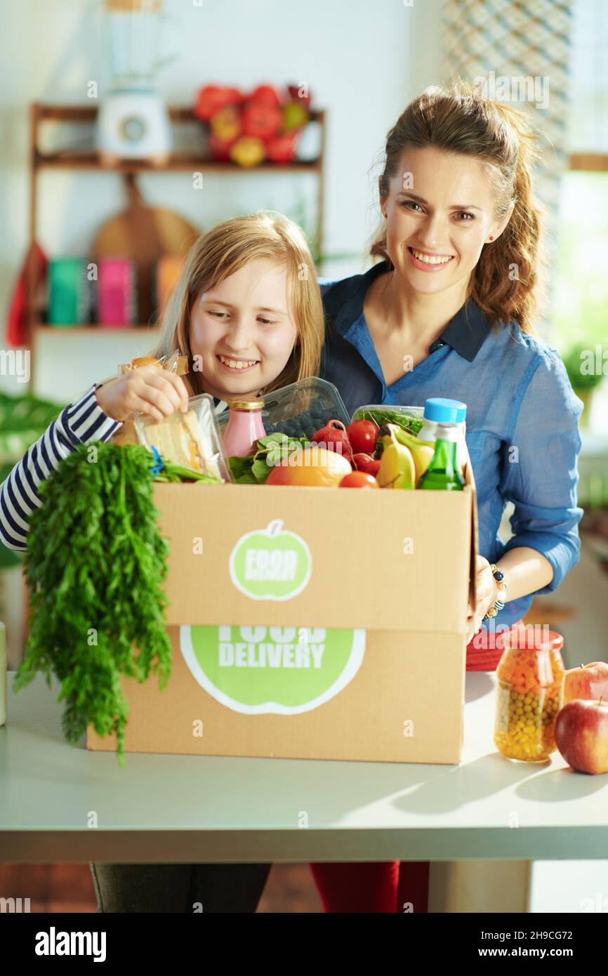 Food delivery. smiling modern mother and daughter with food box in the
