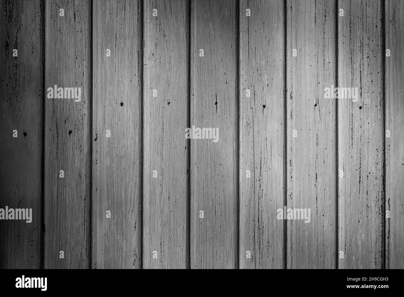 Front view of an old weathered and painted wooden wall or wood paneling. Abstract high resolution full frame textured background in black and white. Stock Photo