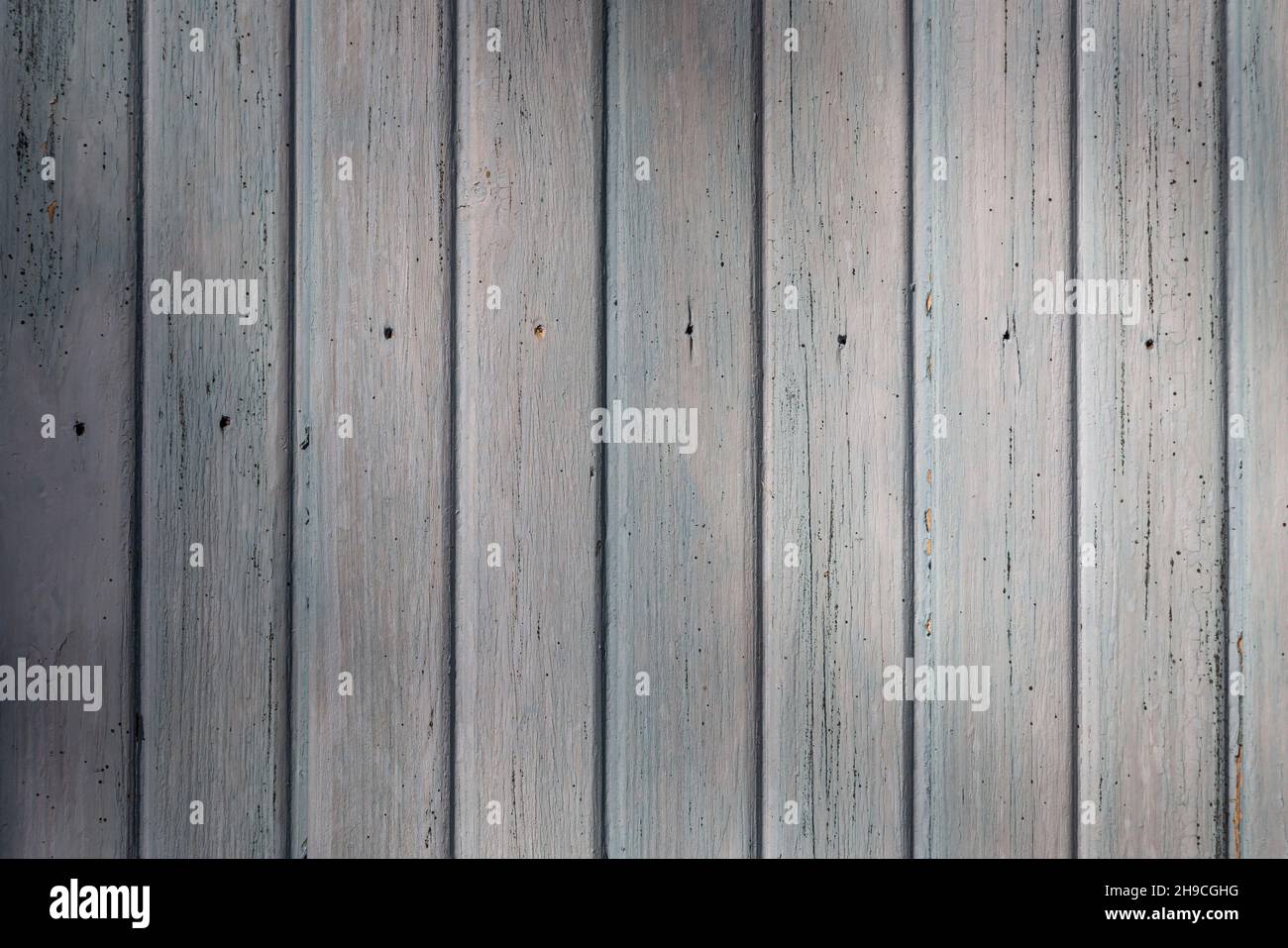 Front view of an old weathered and painted wooden wall or wood paneling. Abstract high resolution full frame textured background. Stock Photo