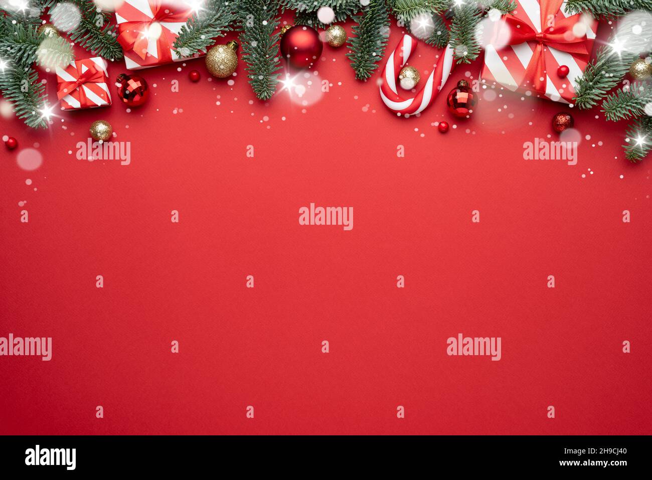 Red Christmas background with fir ornaments and holiday gifts. Flat lay, top view and copy space for text Stock Photo