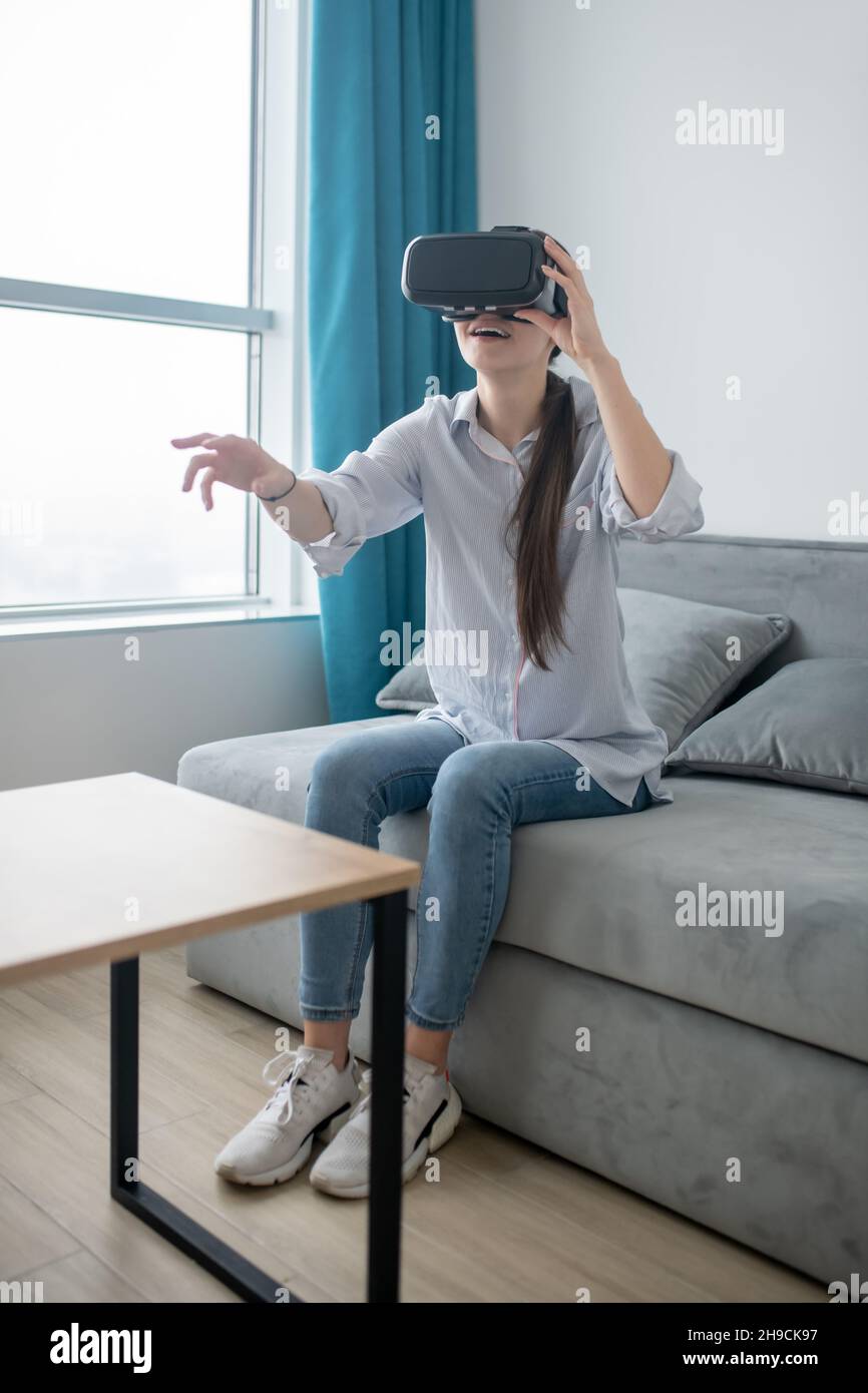 Astounded dark-haired lady playing a 3D game Stock Photo