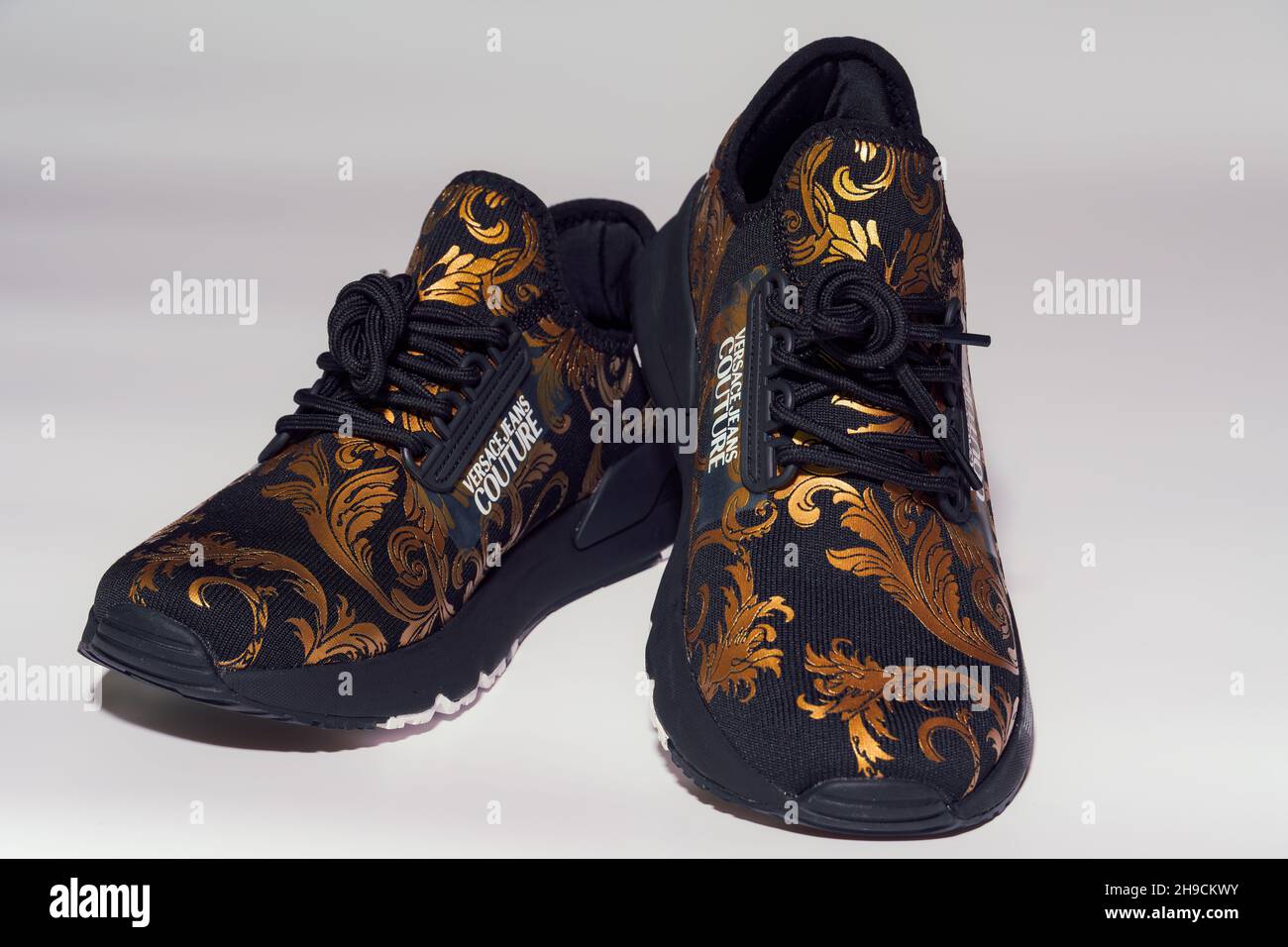 Versace Jeans Couture shoes with golden design. Display of a pair of  Italian designers sneakers with company logo, against white background  Stock Photo - Alamy