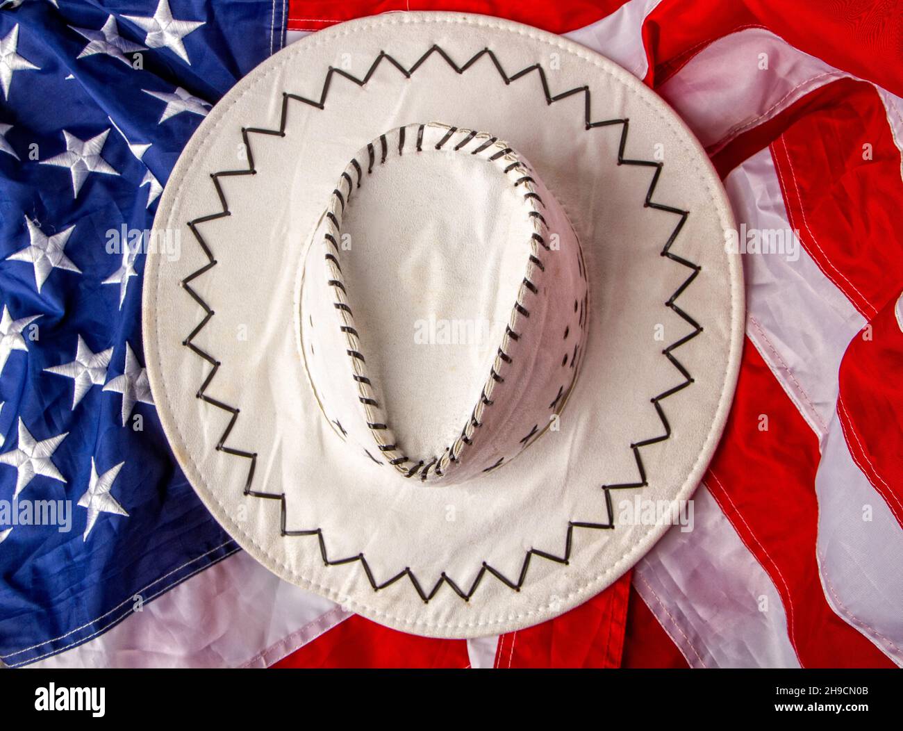 white classic wide-brimmed cowboy hats on the background of the flag of the united states of america Stock Photo