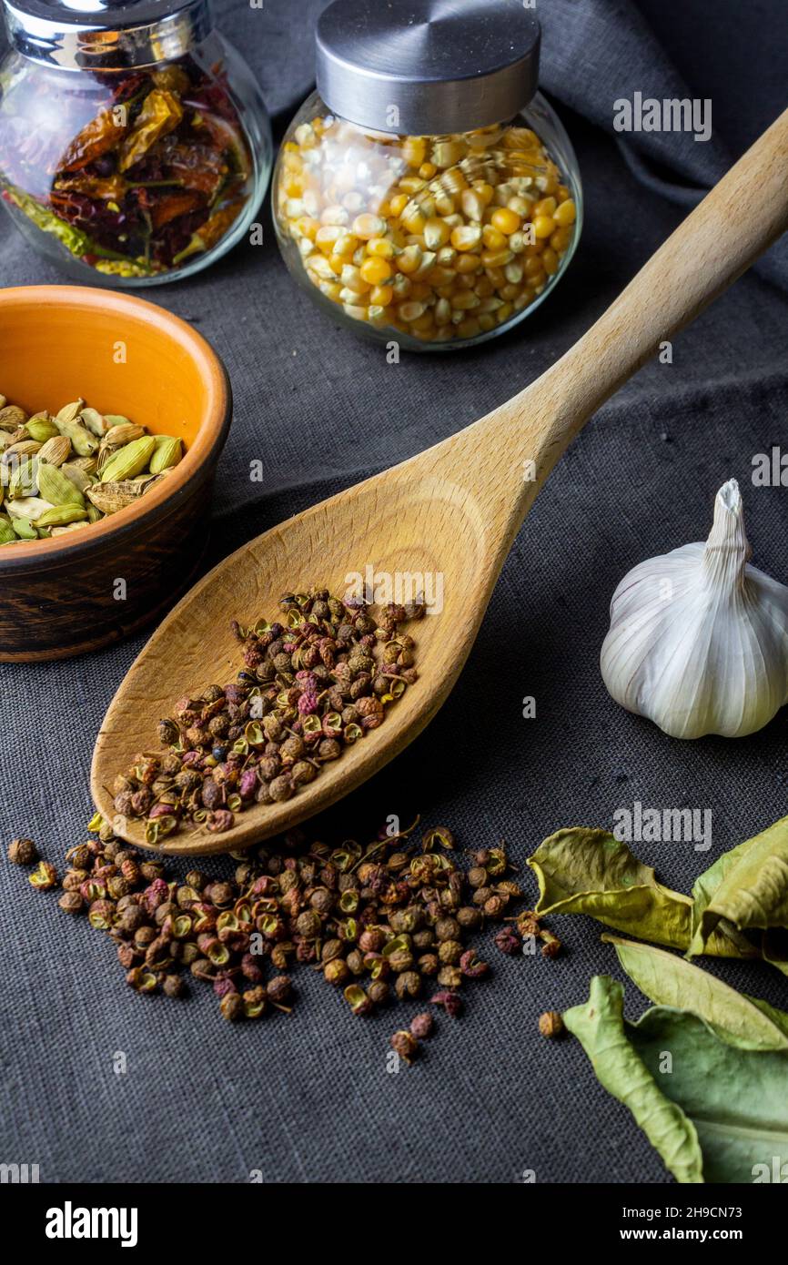 cardamon clay pot, sichuan paper in wood spoon, chilli paper and ...