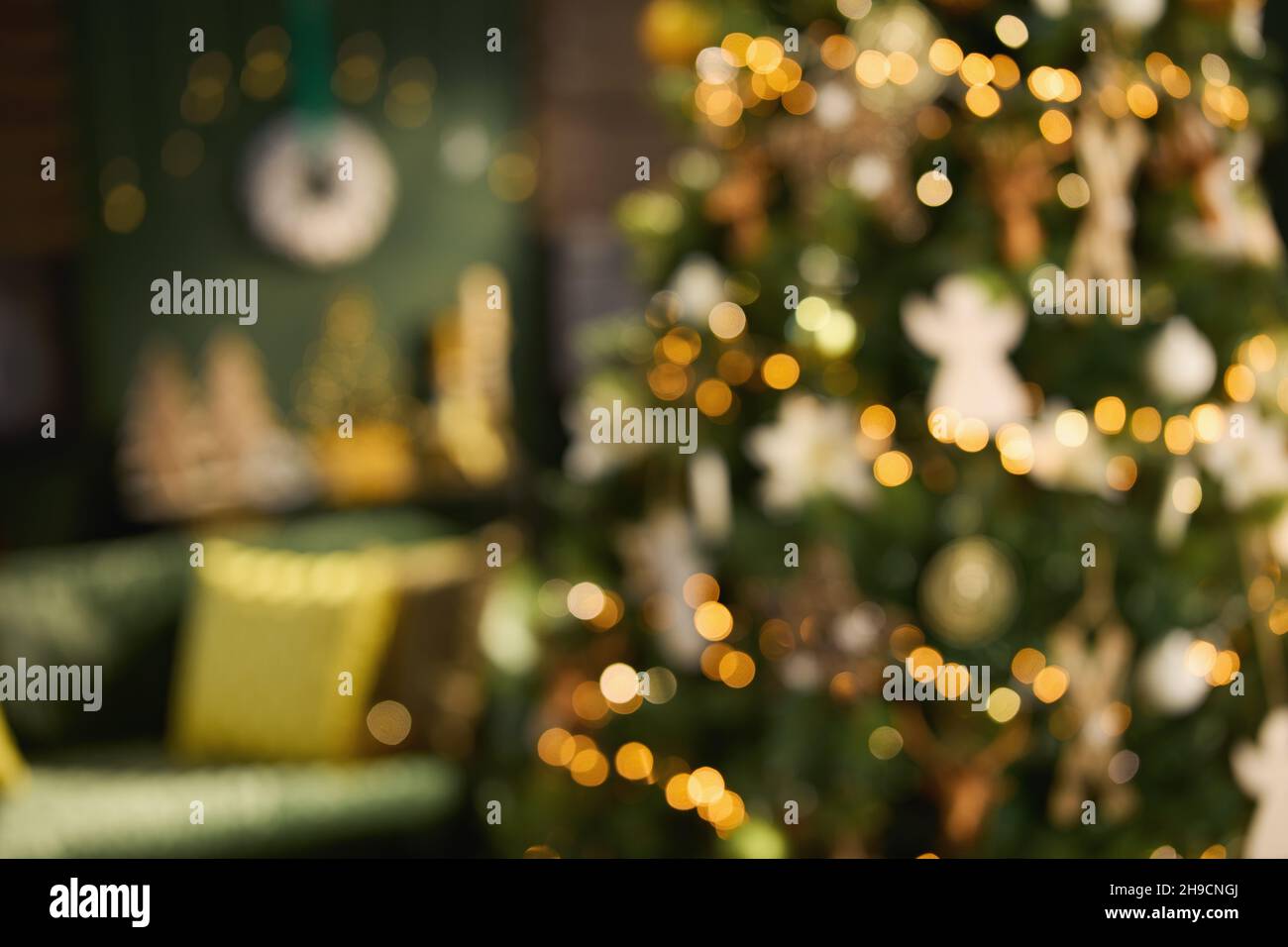 blurred Christmas decorated green modern house with big Christmas tree. Stock Photo