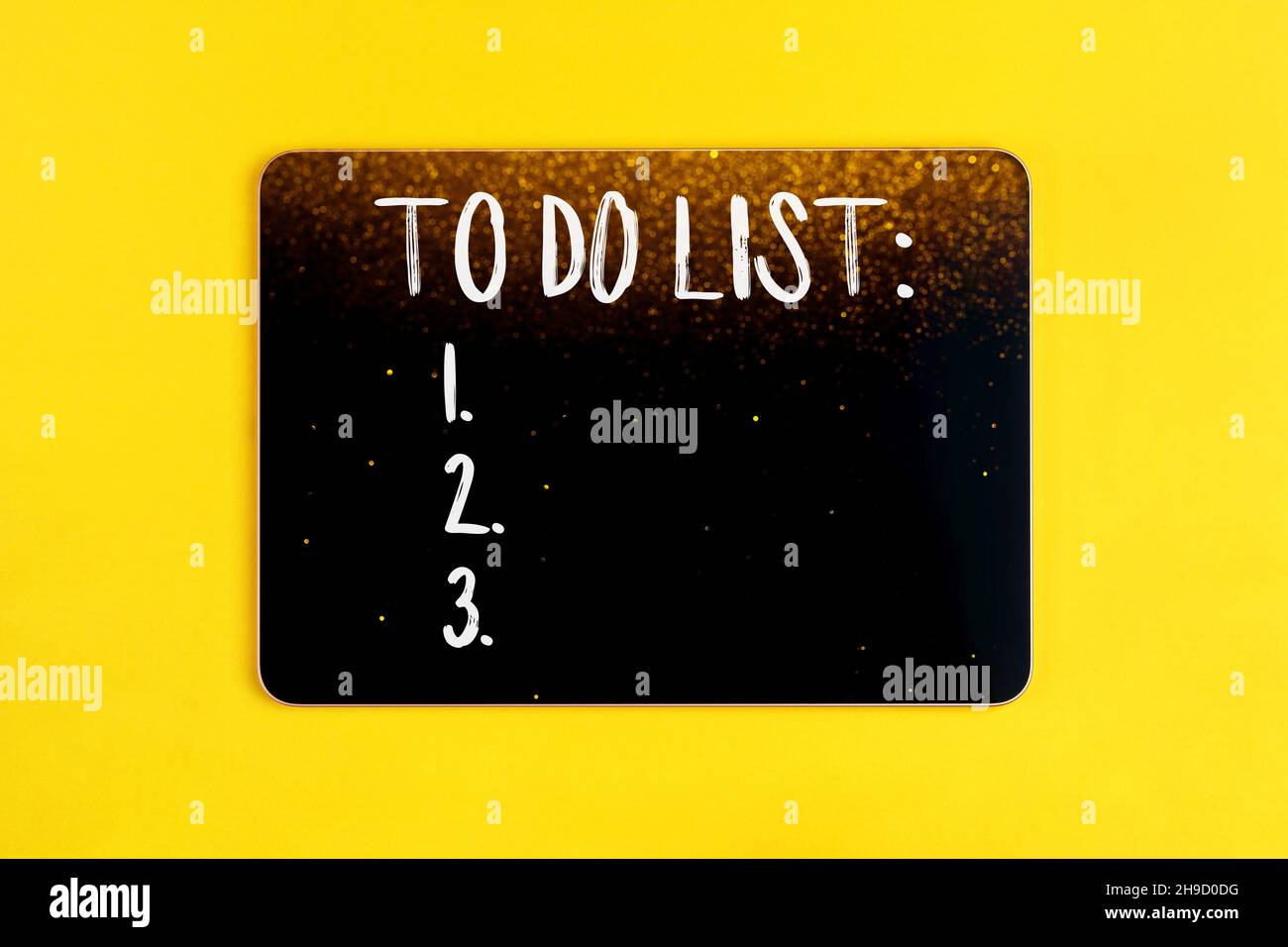 Black digital tablet with to do list on yellow background with blurred lights bokeh Stock Photo