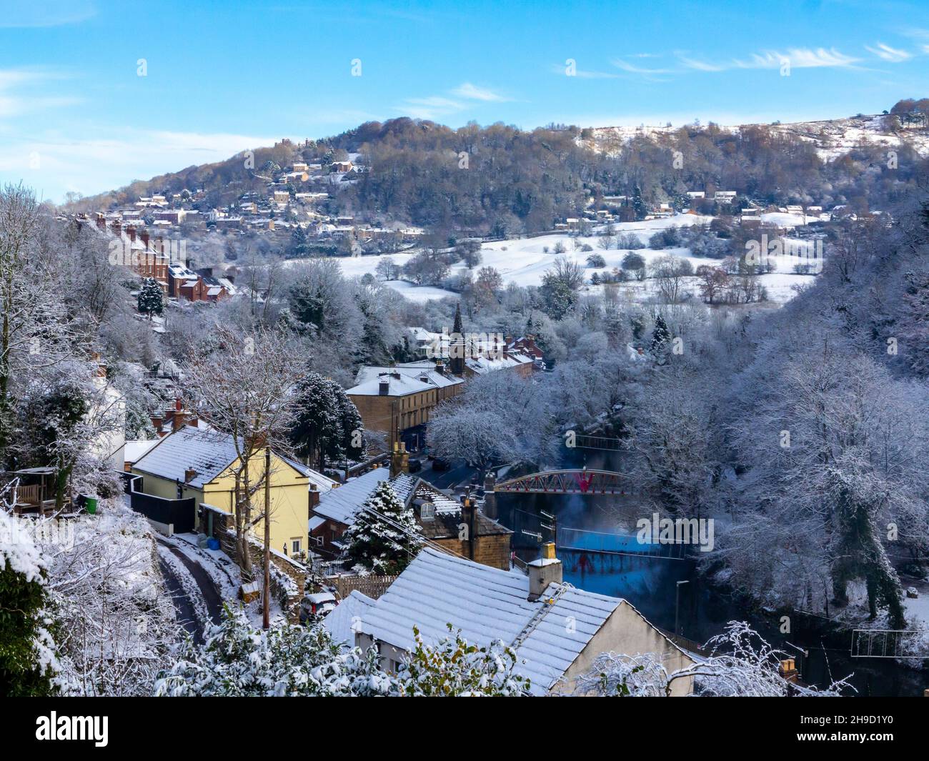 Snow covered landscape with trees at Matlock Bath in the Derbyshire Peak District England UK with River Derwent in the foreground. Stock Photo