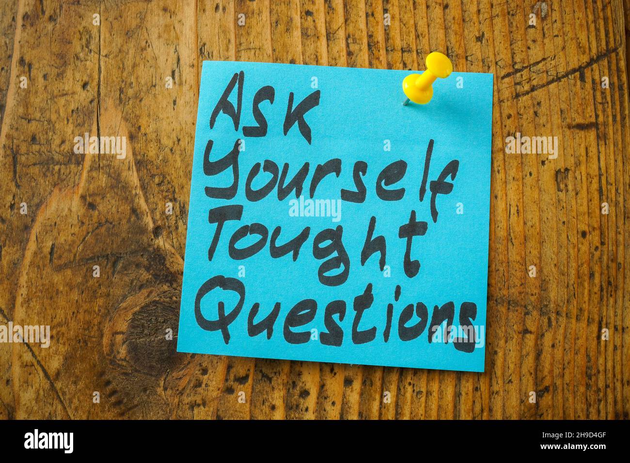 Pinned sticker with an inscription ask yourself tough questions. Stock Photo