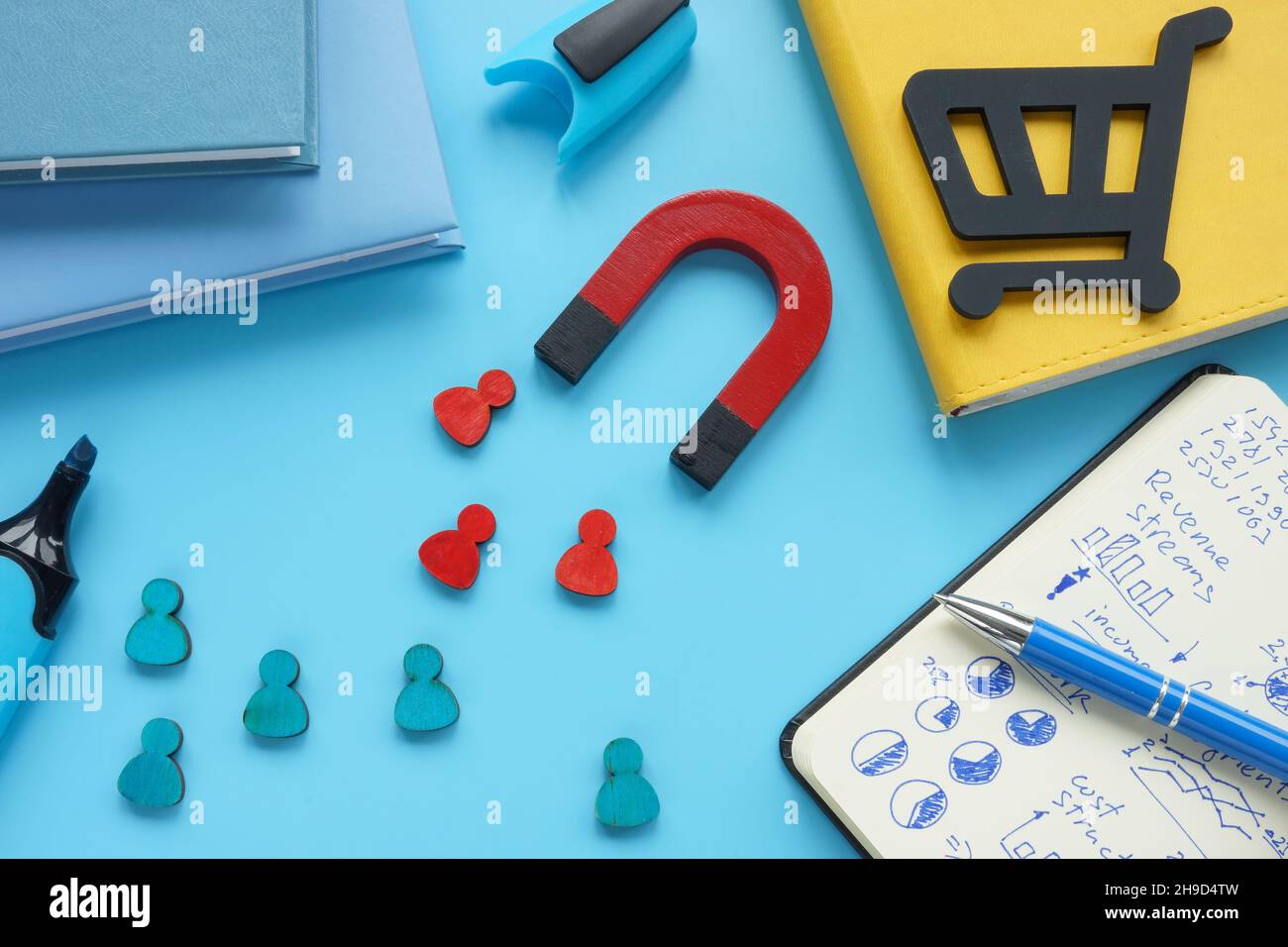 Leads and clients attraction concept. Magnet and figurines on the table. Stock Photo