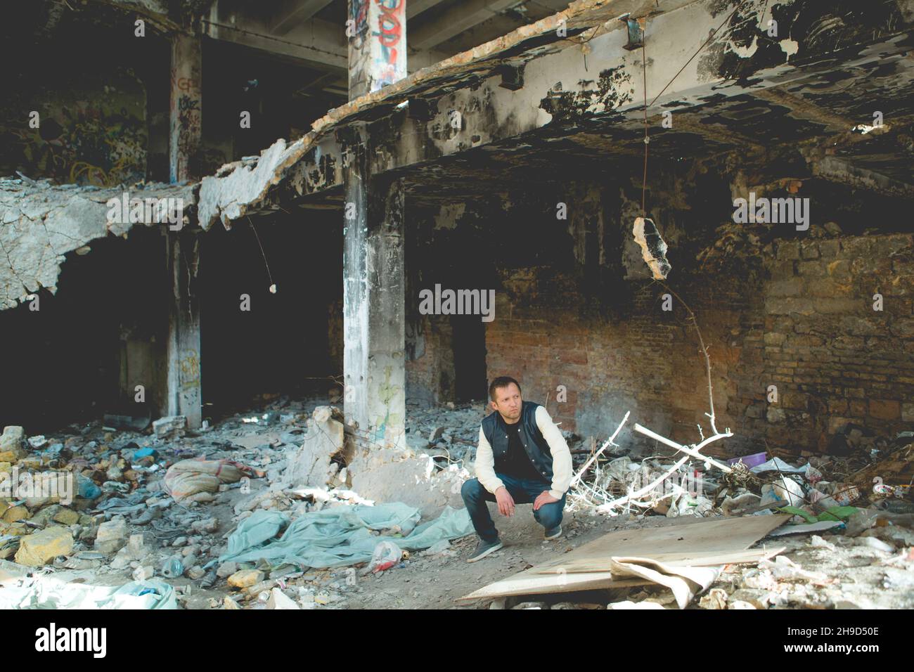 man in destroyed building against background of graffiti. Portrait of ...