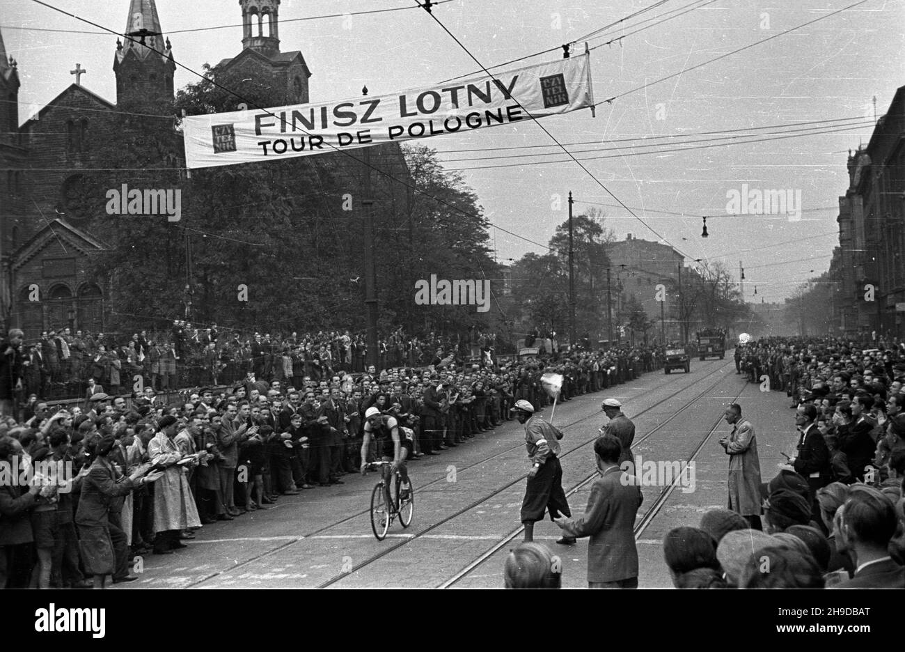 Katowice, 1947-09-25. Pierwszy powojenny Wyœcig Kolarski Dooko³a Polski (VI Tour de Pologne) na trasie Kraków–Warszawa. Nz. etap pierwszy: Kraków-Bytom; finisz lotny na ul. Warszawskiej w Katowicach. Pierwszy przez liniê pomiaru czasu przeje¿d¿a Józef Kapiak (ps. Szpagat) z Klubu Elektrycznoœæ Warszawa. W tle koœció³ ewangelicki z XIX wieku. bk/mgs PAP Bytom, Sept. 25, 1947. The first after the war Cycling Race around Poland (VI Tour de Pologne) from Cracow to Warsaw. Pictured: the first stage Cracow-Bytom. bk/mgs PAP Stock Photo