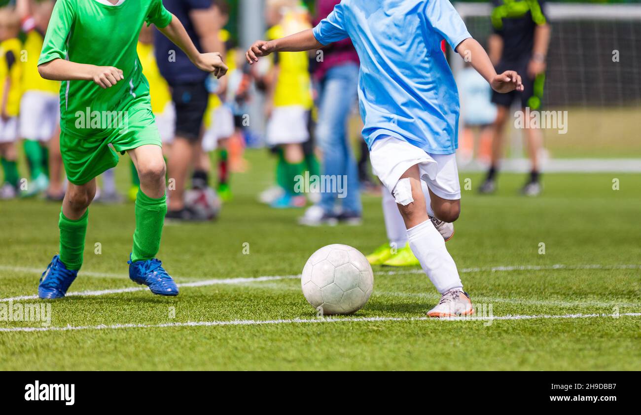 Young boys playing soccer game. Kids having fun in sport. Happy kids compete in football game. Running soccer players. Competition between players run Stock Photo