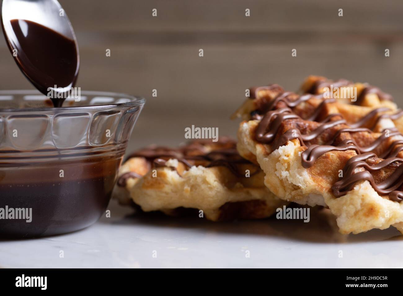 Stacked Belgian Waffles with Chocolate Sauce and Spoon Stock Photo - Alamy