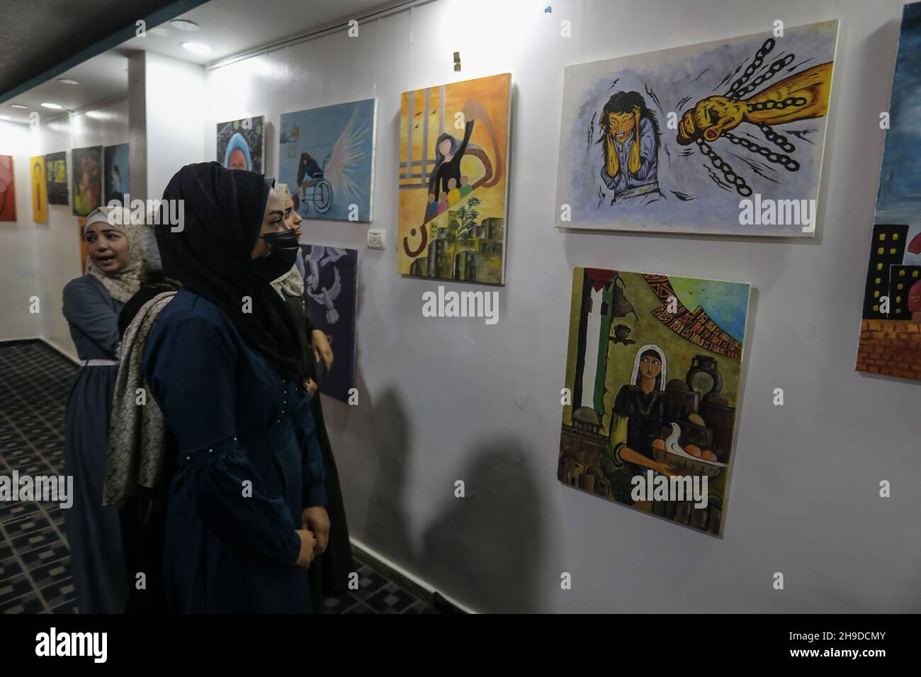 Palestinians visit an art exhibition as part of a campaign to raise awareness of violence against Women, in Gaza Strip, on December 6, 2021. Stock Photo