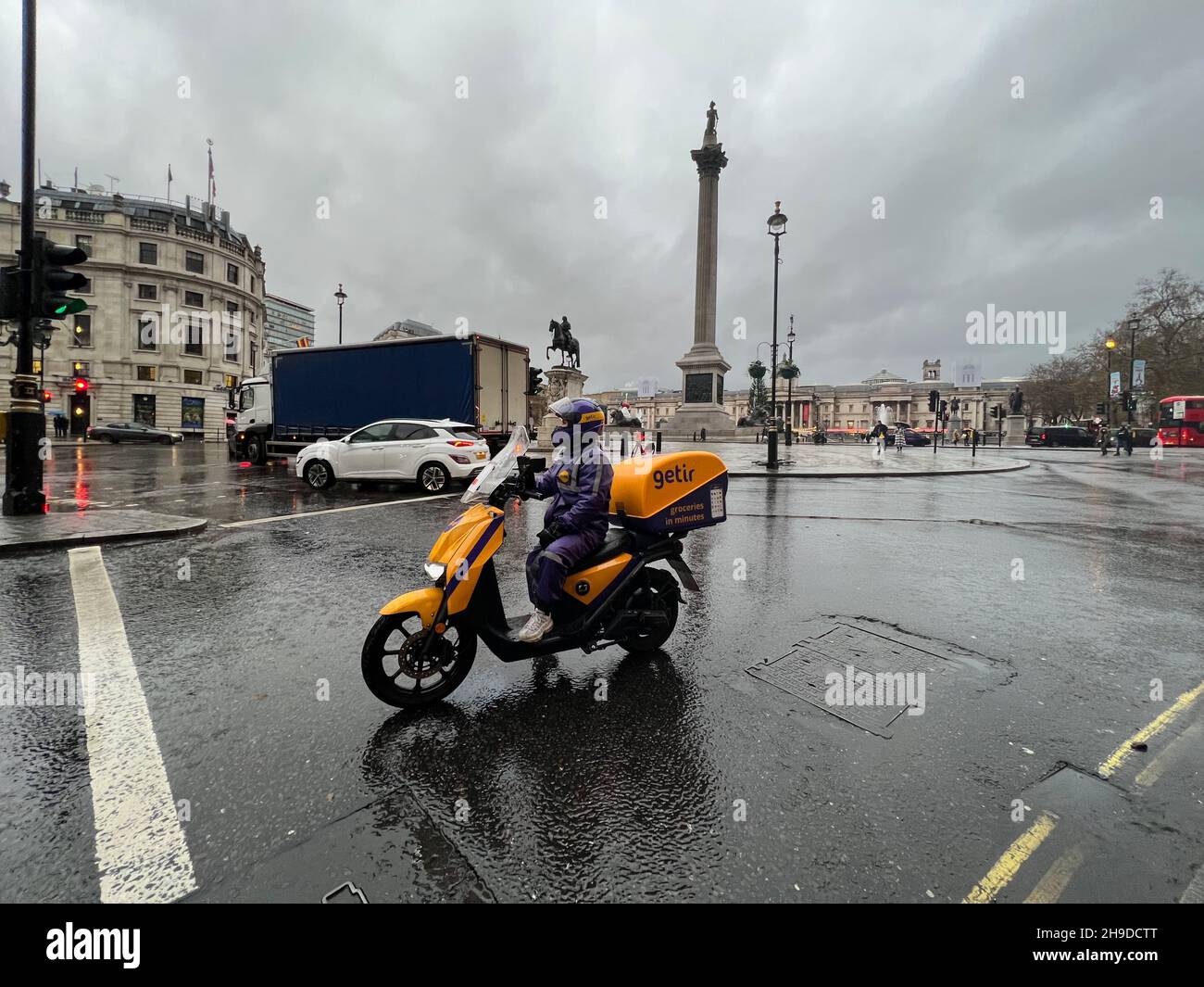London, UK. 06th Dec, 2021. A driver for Getir delivery service sits on her scooter near Trafalgar Square in London on Dec. 6, 2021. Getir is an online grocery delivery platform that promises to deliver products within 10 minutes. Getir was started in Istanbul in 2015 and launched in London in January 2021. The start-up also has service in Amsterdam, Berlin, and Paris. (Photo by Samuel Rigelhaupt/Sipa USA) Credit: Sipa USA/Alamy Live News Stock Photo