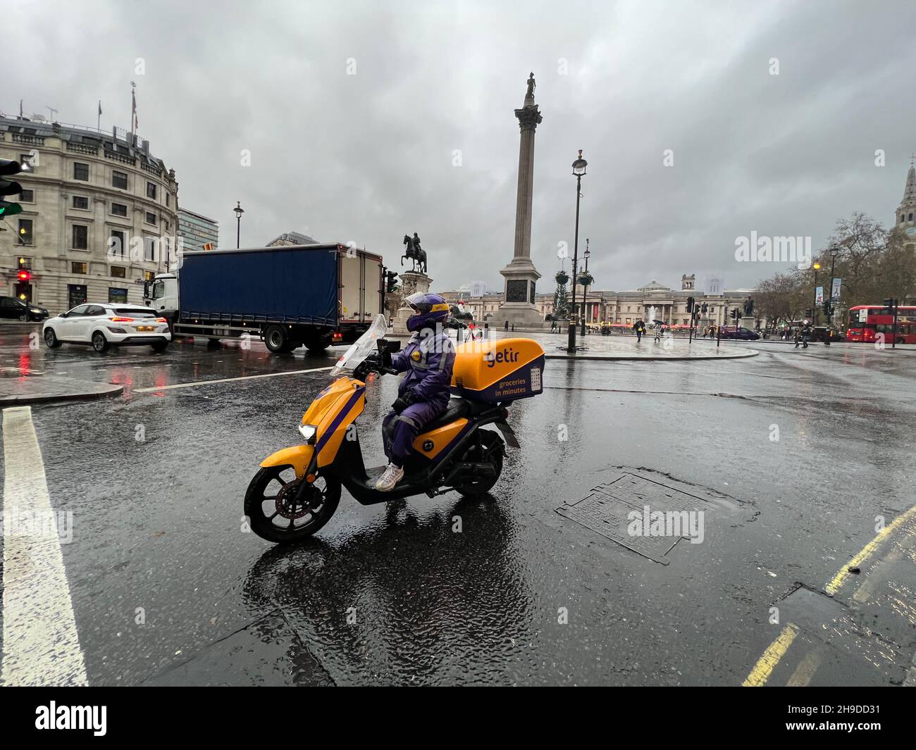 London, UK. 06th Dec, 2021. A driver for Getir delivery service sits on her scooter near Trafalgar Square in London on Dec. 6, 2021. Getir is an online grocery delivery platform that promises to deliver products within 10 minutes. Getir was started in Istanbul in 2015 and launched in London in January 2021. The start-up also has service in Amsterdam, Berlin, and Paris. (Photo by Samuel Rigelhaupt/Sipa USA) Credit: Sipa USA/Alamy Live News Stock Photo