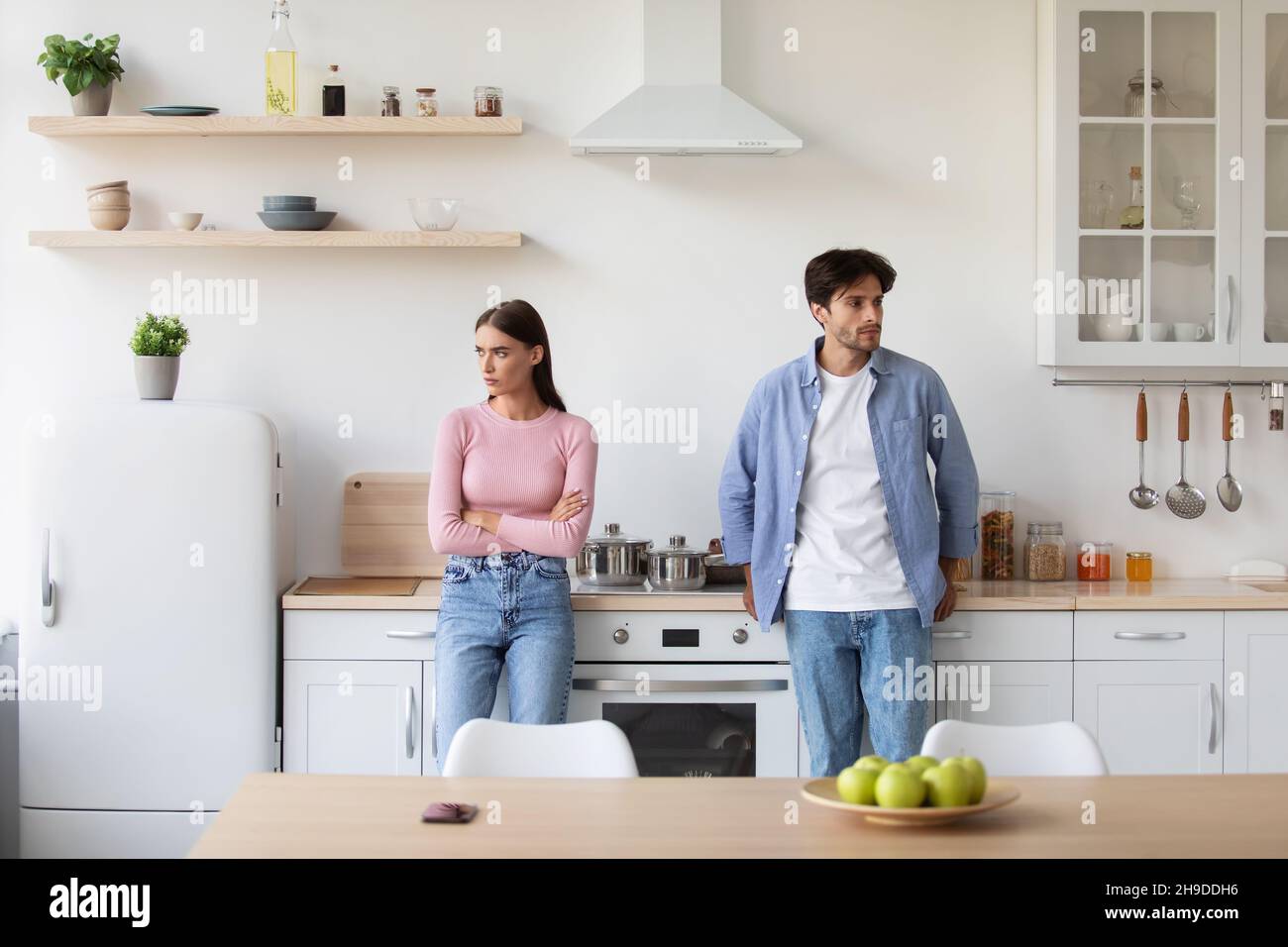 Offended young man ignore lady on kitchen interior. Negative emotions, relationship problems at home Stock Photo