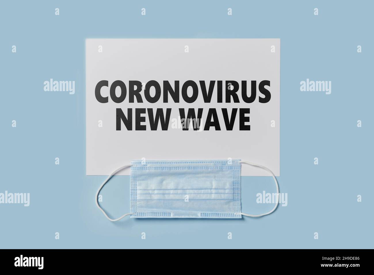 Coronavirus new wave text on paper and face mask. Lockdown, quarantine due to new Covid-19 variant Stock Photo