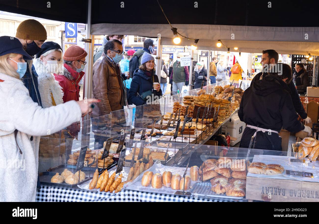 Bakers stall UK; people buying bread and pastries from a market bread stall, Saffron Walden market, Saffron Walden Essex UK Stock Photo