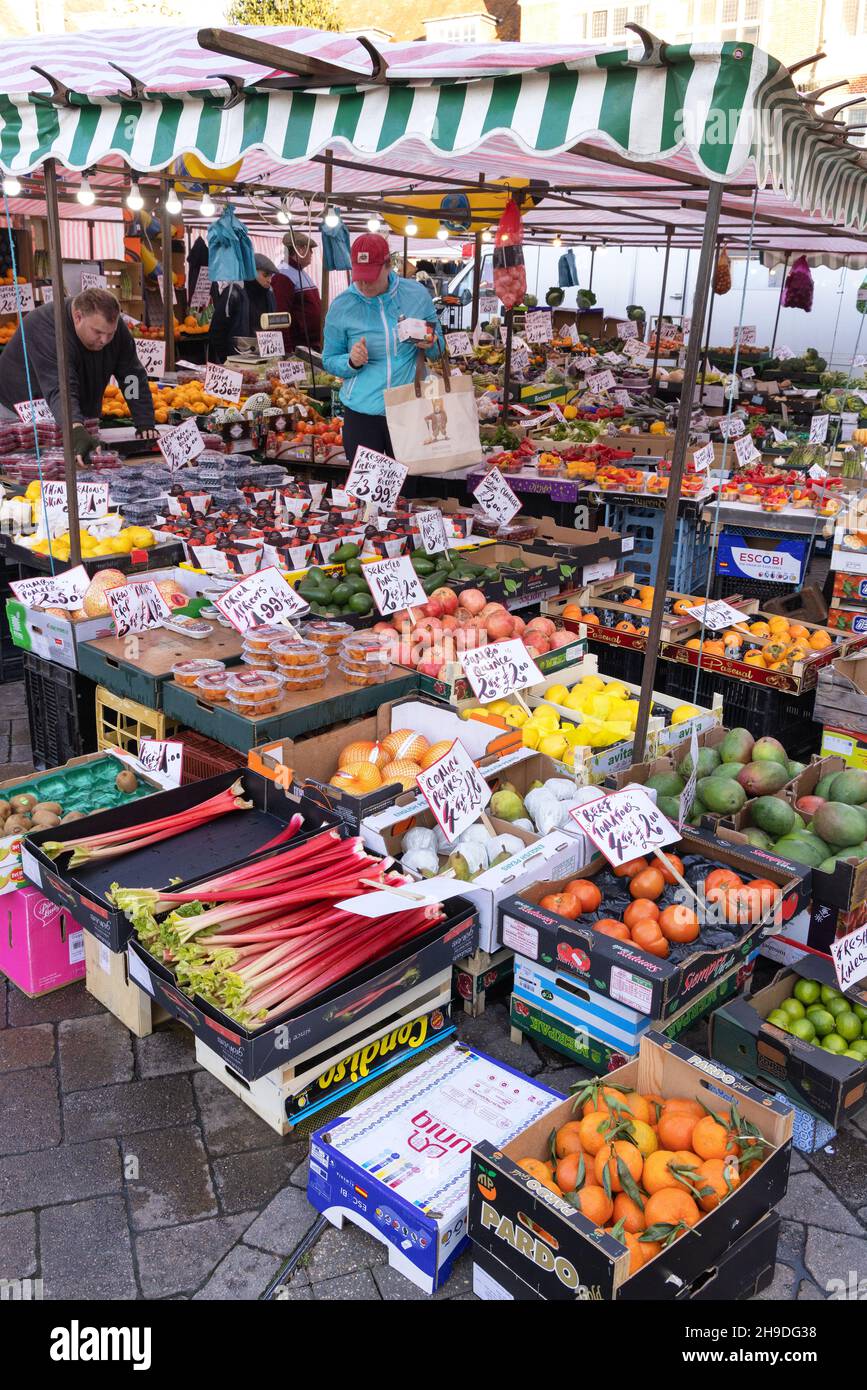 Market UK; people shopping for groceries in a greengrocer market stall, Saffron Walden Market, Saffron Walden, Essex UK Stock Photo