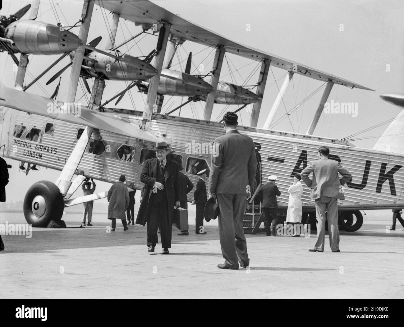 A vintage black and white photograph taken in 1938, showing a Short L.17 Syrinx, serial number G-ACJK, of Imperial Airways at Croydon Aerodrome, outside London. Image showing passengers disembarking from the aircraft. Stock Photo