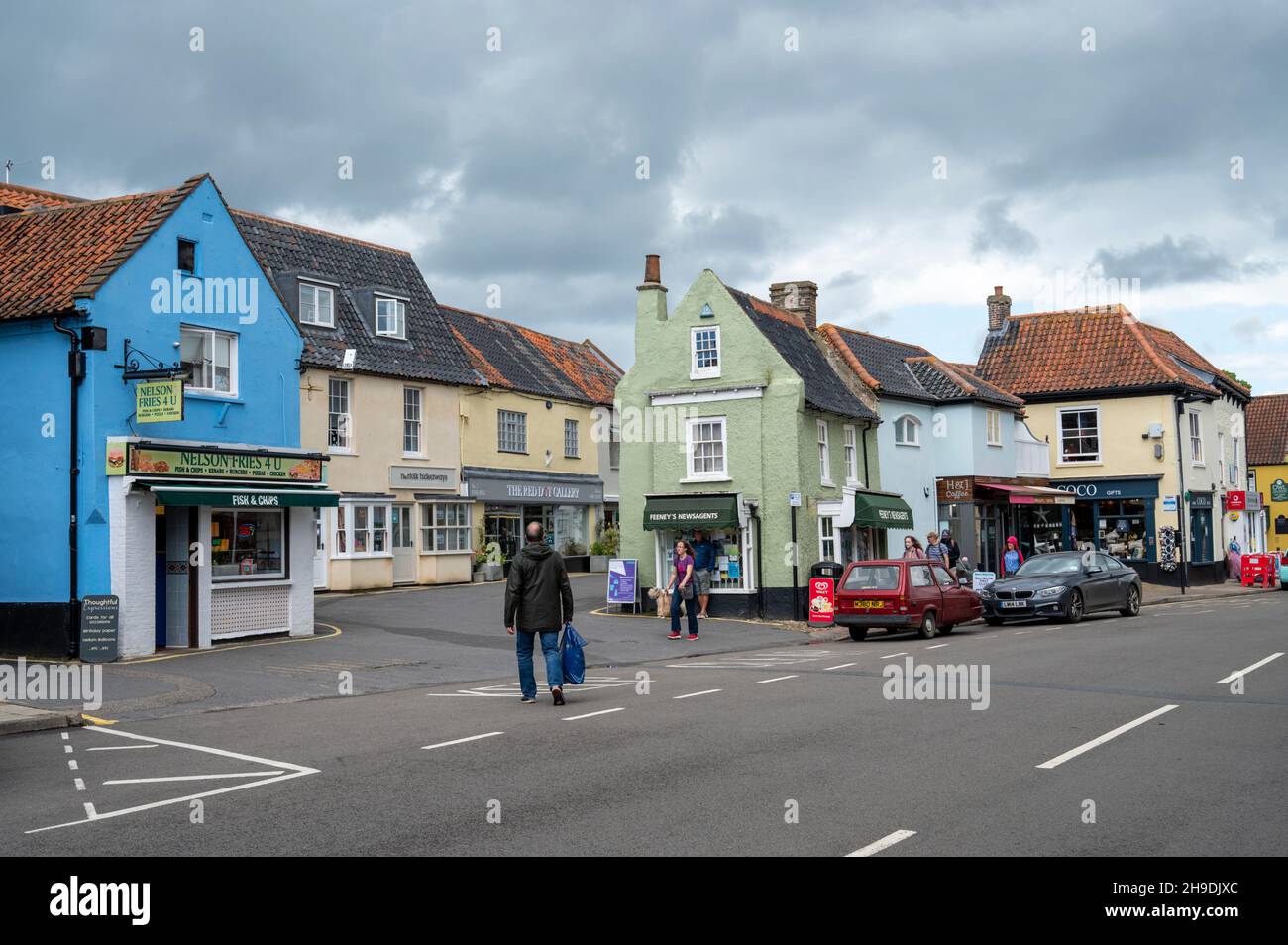 The main high street with shops, and parked cars in the market town of Holt, Norfolk, UK Stock Photo