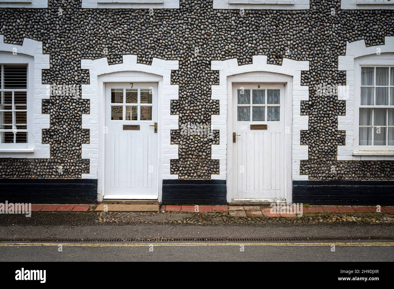 Old houses in Holt, Norfolk UK  with striking white painted windows and doors and flint walls. Stock Photo