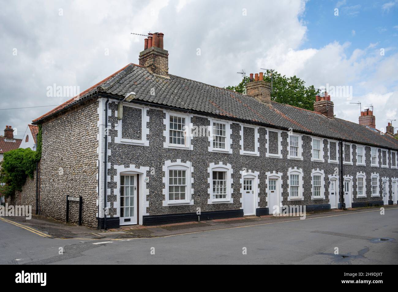 Old houses in Holt, Norfolk UK  with striking white painted windows and doors and flint walls. Stock Photo
