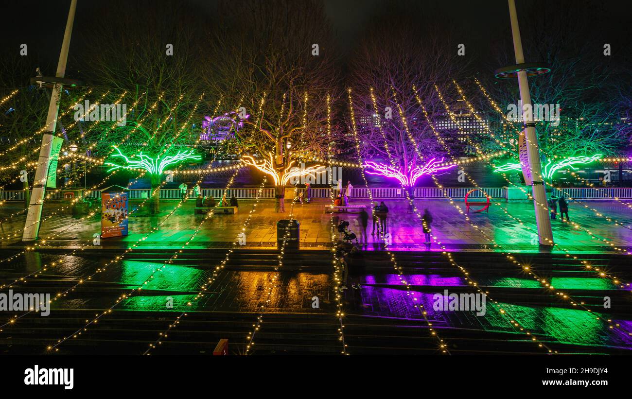 The Southbank in London looks colorful in the evening rain as a few tourists enjoy the evening. Stock Photo