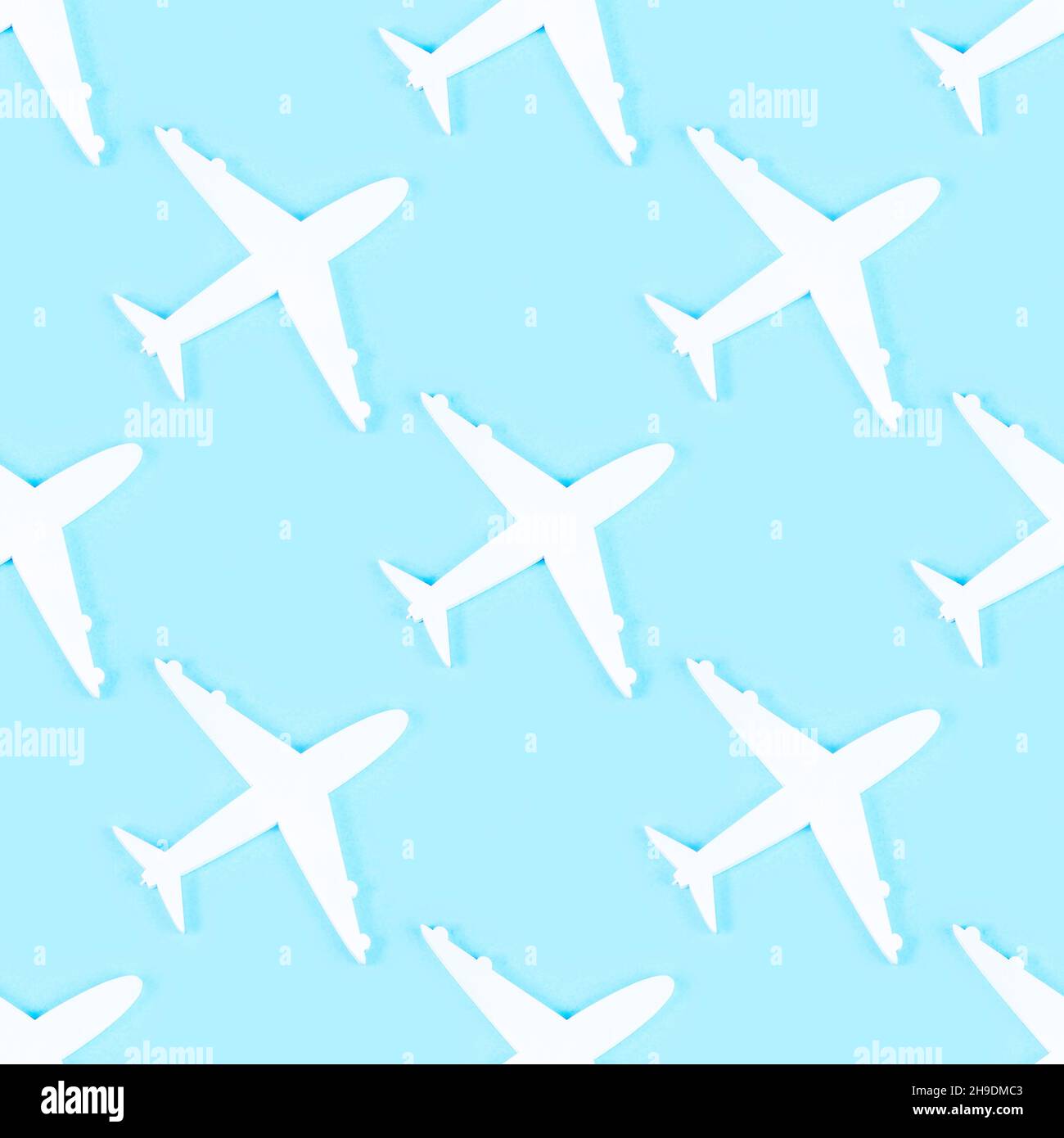 White plane silhouette repeat seamless pattern on light blue background. Stock Photo