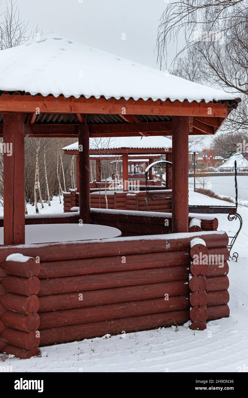 wooden gazebos standing one after another in the snow in winter Stock ...
