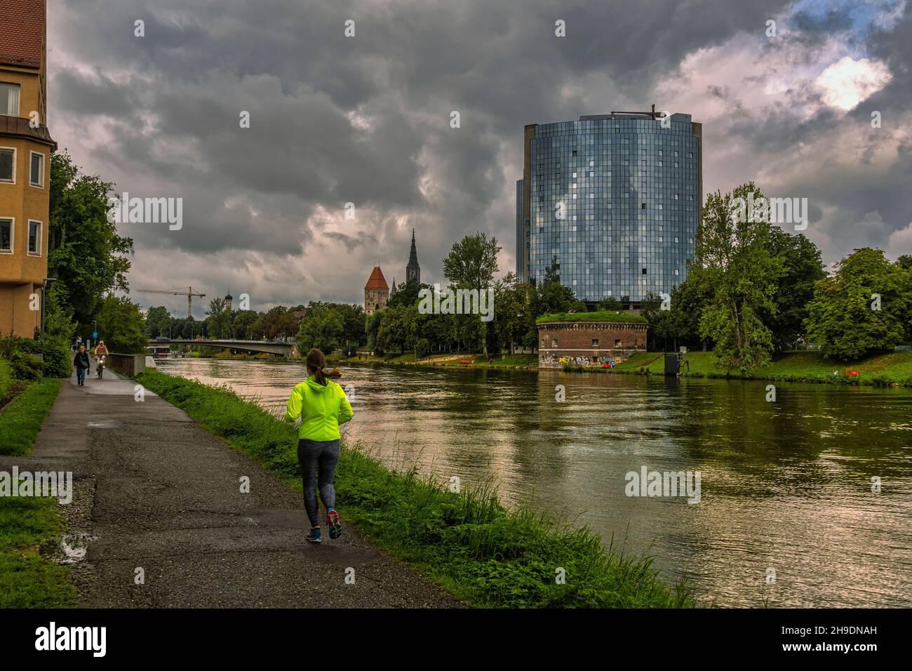 Pedestrian and cycle path along the Danube through the medieval city of Ulm. Sportsmen cycling and jogging. Ulm, Tubingen, Donau-Iller region, Germany Stock Photo