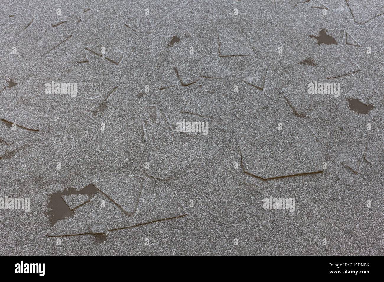 background or texture a layer of thin gray ice covered with snow Stock Photo