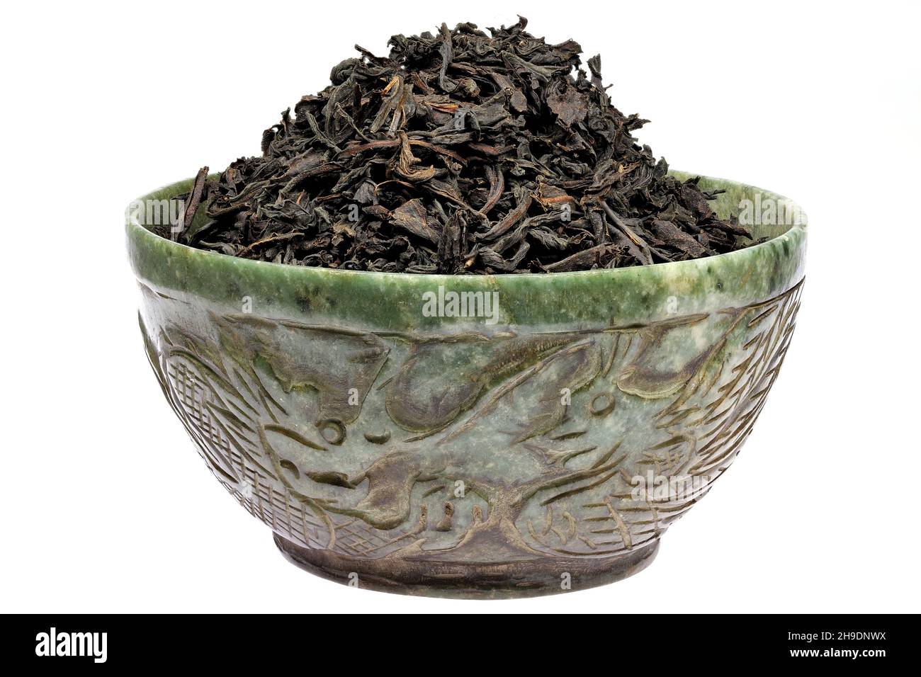 Ceylon Black Tea in a vintage jade bowl isolated on white background Stock Photo