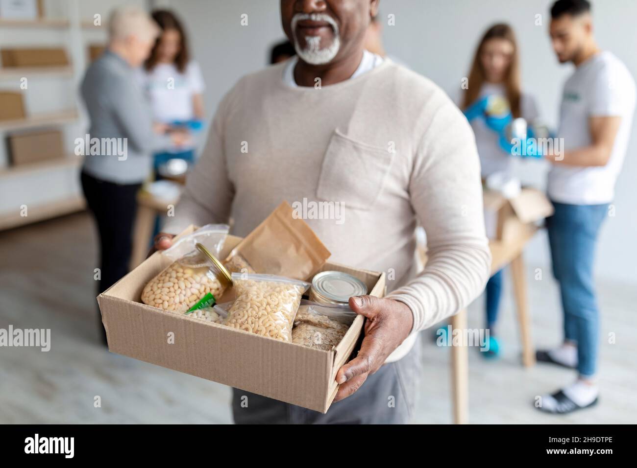 Humanitarian aid. African american elderly man holding box with