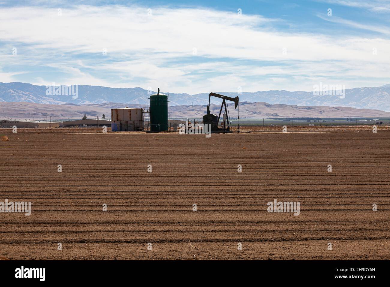 Oil well in fallow crop field, Arvin, Kern County, California, USA Stock Photo